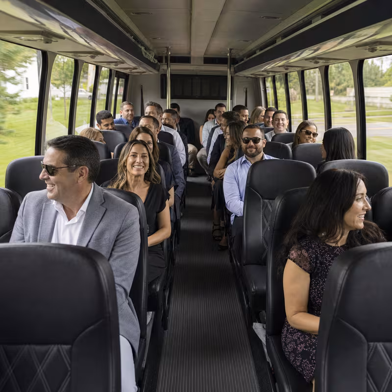 Group boarding a white charter bus for Private Event Transportation transportation in Fort Myers