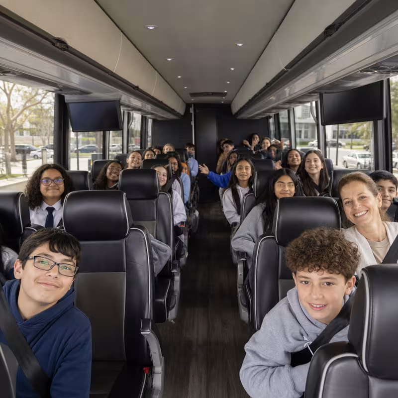 Group boarding a white charter bus for School Transportation transportation in Fort Myers