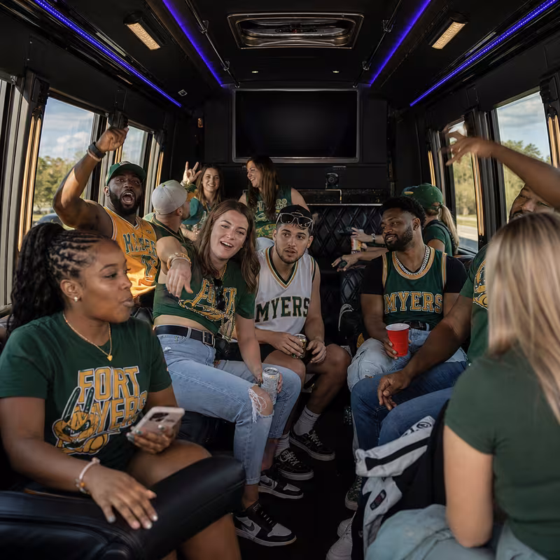 Group boarding a white charter bus for Sporting Event Transportation transportation in Fort Myers