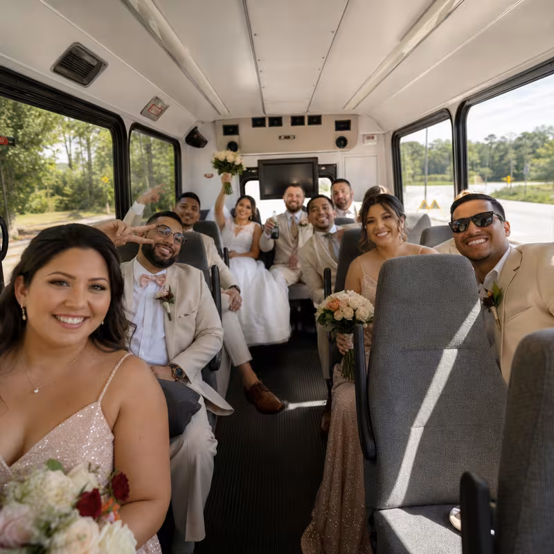 Group boarding a white charter bus for Wedding Transportation transportation in Fort Myers